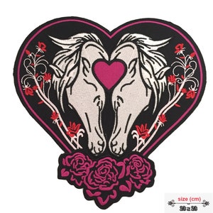 Può includere: Toppa da stirare ricamata con due teste di cavallo bianche che si guardano con un cuore rosa al centro. I cavalli sono circondati da rose e viti rosa e rosse su uno sfondo nero. La toppa ha la forma di un cuore e misura 23 x 23 cm.