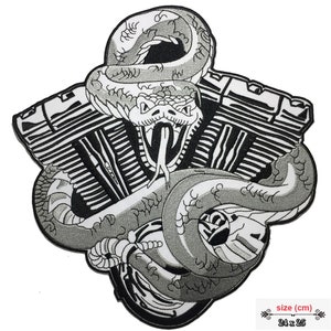 May include: Black and white embroidered patch of a snake wrapped around a motorcycle engine. The snake's head is facing forward with its mouth open and fangs showing. The patch measures 24 inches by 25 inches.
