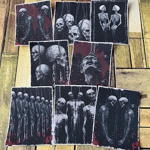 May include: Set of eight black and white iron-on patches featuring a macabre theme with hanging skeletons and skulls. The patches have a distressed look and include the text "Hammer Horror".