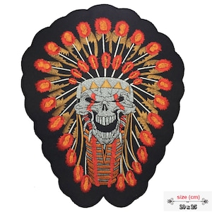 May include: Embroidered iron-on patch featuring a skull wearing a headdress with red and gold feathers. The skull has red eyes and a toothy grin. The patch is 20 x 25 cm.