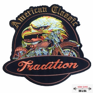 Könnte beinhalten: Gestickter Patch mit einem Weißkopfseeadler mit einem Oldtimer-Motorrad, umgeben vom Text "American Classic Tradition". Der Patch ist schwarz mit orangefarbenen und gelben Akzenten. Größe: 25 x 24 cm.