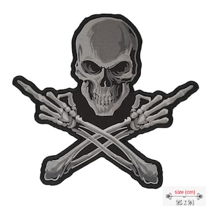 Könnte beinhalten: Ein grauer gestickter Patch mit einem Totenkopf mit gekreuzten Knochen, die beide den Mittelfinger zeigen. Der Patch ist 25 cm x 24 cm groß.