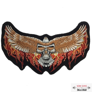 May include: Embroidered patch featuring a skull with eagle wings and flames. The skull is white with black eyes and a black mouth. The wings are brown and white, and the flames are red and orange. The patch is 24 x 16.5 cm.