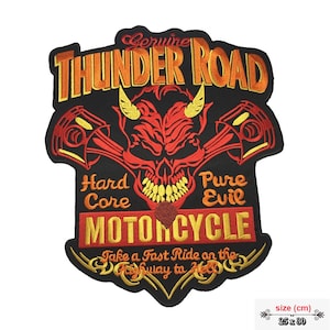 Può includere: Una toppa ricamata nera con un teschio di diavolo rosso e pistoni incrociati. Il testo "Genuine Thunder Road Hard Core Pure Evil Motorcycle" è in giallo e rosso. Il testo "Take a Fast Ride on the Highway to Hell" è in oro. La toppa misura 25 x 30 cm.