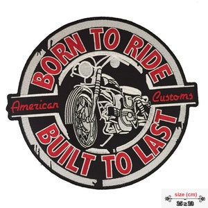 May include: Black and white embroidered patch with a motorcycle design. The patch reads "Born to Ride American Customs Built to Last" in red and white lettering. The patch is 25 cm by 23 cm.