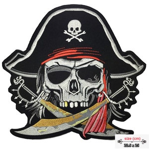 May include: Embroidered iron-on patch featuring a skull wearing a pirate hat with crossed swords and a red bandana. The skull is white with black eyes and a black and gold bandana. The patch is 22.5 cm by 25 cm.