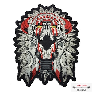 May include: Embroidered iron-on patch featuring a skull wearing a Native American headdress with red, white, and black feathers. The skull has red and white face paint and yellow eyes. The patch measures 19 x 22.5 cm.