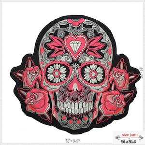 Könnte beinhalten: Ein gestickter Patch in Schwarz und Silber mit einem Zucker Totenkopf mit rosa Rosen und einem Diamantenherz. Der Totenkopf hat komplizierte Details und ein florales Design. Der Patch ist 9,5 Zoll breit und 21,5 Zoll hoch.