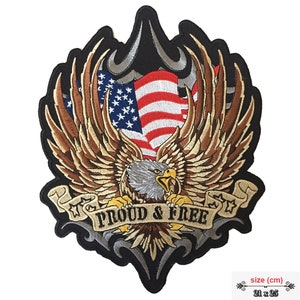 May include: Embroidered patch featuring a bald eagle with outstretched wings holding an American flag. The eagle is clutching a banner that reads "PROUD & FREE". The patch is 21 inches by 25 inches.