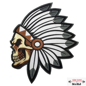 May include: Embroidered iron-on patch of a skull wearing a brown and white headdress with feathers. The patch is 24 x 21.5 cm.