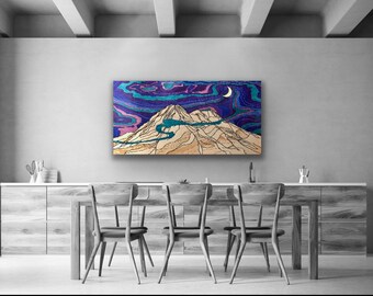 Può includere: Un dipinto astratto incorniciato che rappresenta una catena montuosa sotto un cielo notturno con una luna crescente. Il dipinto è in tonalità di blu, viola e bianco, con una catena montuosa beige in primo piano. Il dipinto è appeso a una parete in una sala da pranzo con un tavolo e sedie in legno.