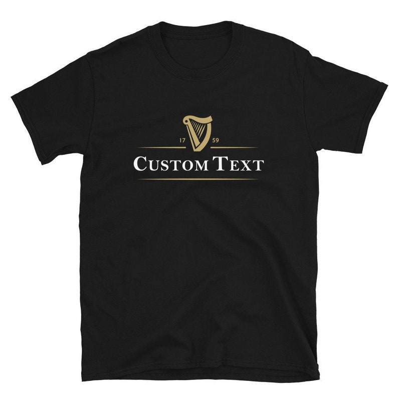 Op de afbeelding: Zwart T-shirt met korte mouwen, een gouden harp logo, de nummers "17" en "59" en de witte tekst "CUSTOM TEXT". Het shirt is gemaakt van een zacht materiaal.