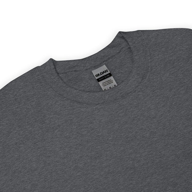 May include: A dark gray t-shirt with a Gildan Heavy Blend label attached to the neck.