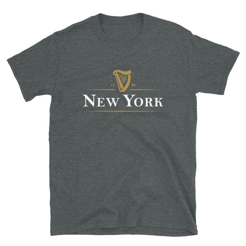 May include: A dark heather grey t-shirt featuring a gold harp logo and the text "NEW YORK" underneath. The harp logo has the numbers "17" and "89" on either side.