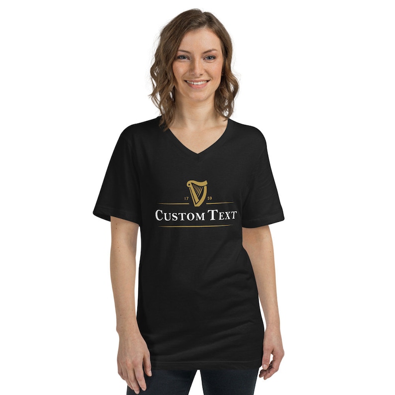 May include: Black V-neck t-shirt with a gold harp logo and the text "CUSTOM TEXT" printed on the front.