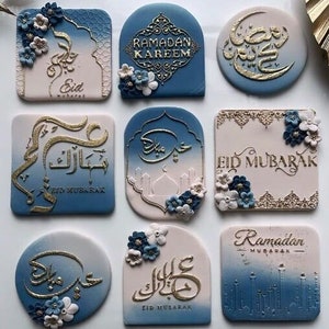 Peut inclure: Neuf carreaux en céramique décoratifs avec des fonds bleus et roses. Les carreaux présentent une calligraphie dorée et les phrases "Eid Mubarak", "Ramadan Kareem" et "Ramadan Mubarak". Certains carreaux présentent également des embellissements floraux.