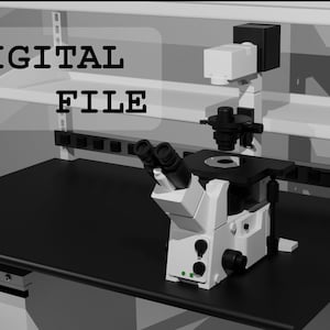 Può includere: Un microscopio bianco con oculari neri e un tavolino nero su un bancone nero. Il microscopio è attaccato a uno scaffale bianco con una ciabatta nera. Il testo "DIGITAL FILE" è visibile nell'immagine.