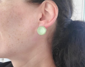 May include: A pair of green oval-shaped earrings with a gold setting.
