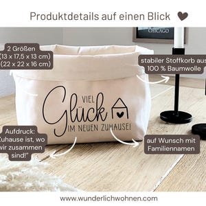 K&ouml;nnte beinhalten: Ein wei&szlig;er Stoffkorb aus Canvas mit schwarzem Text, der "Viel Gl&uuml;ck im neuen Zuhause!" lautet. Der Korb ist in zwei Gr&ouml;&szlig;en erh&auml;ltlich: S (13 x 17,5 x 13 cm) und M (22 x 22 x 16 cm). Der Korb besteht aus 100 % Baumwolle und kann mit einem Familiennamen personalisiert werden.