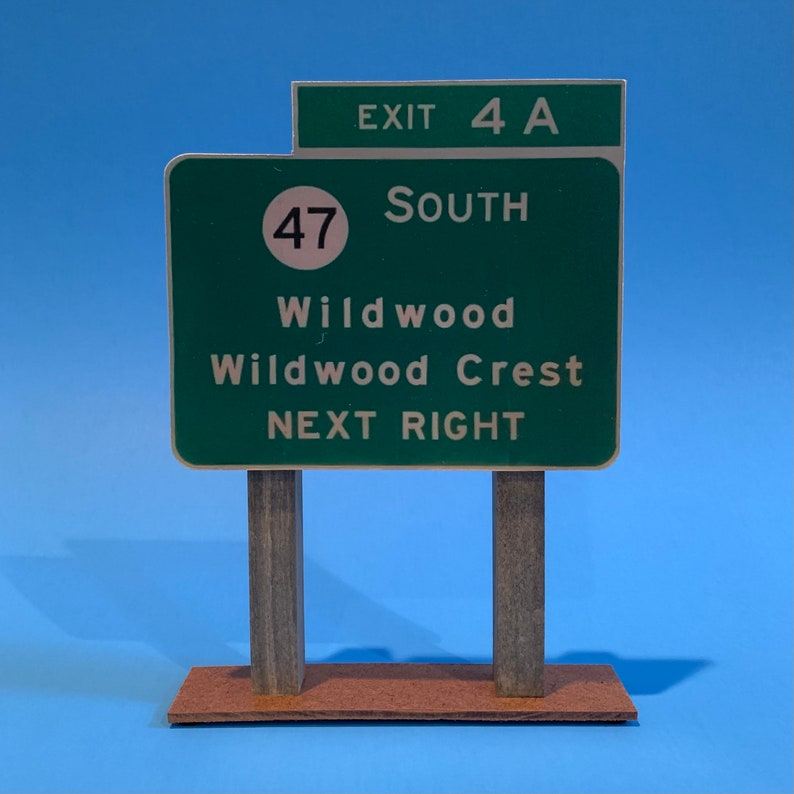 May include: Green highway sign with white text and a white circle with the number 47 inside. The sign reads "Exit 4A South Wildwood Wildwood Crest Next Right".