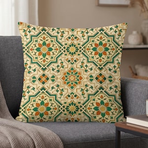 May include: A square throw pillow featuring a repeating geometric pattern in shades of cream, forest green, and burnt orange. The design consists of interlocking star-shaped motifs and floral elements arranged in a symmetrical, tile-like layout.