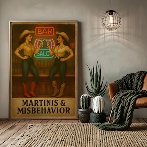 Puede incluir: Un póster enmarcado con el texto "MARTINIS & MISBEHAVIOR" muestra a dos mujeres con sombreros y botas de vaquero, brindando con martinis en un bar. La habitación cuenta con un sillón de cuero, una manta de punto verde y varios cactus y suculentas.