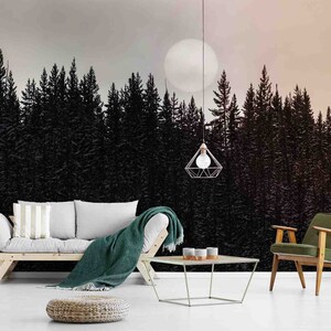 May include: A living room interior with a couch, a chair, a coffee table, and a large wall mural depicting a forest silhouette with a full moon in the sky.