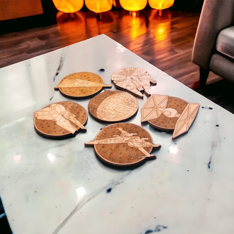 May include: Six wooden coasters featuring iconic spaceships from a popular science fiction franchise. The coasters are laser-cut with detailed designs of a Star Destroyer, Millennium Falcon, Death Star, TIE fighter, X-wing, and a Rebel transport ship.