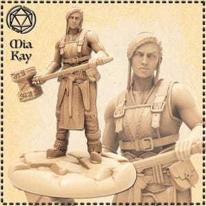 May include: A tan-colored figurine of a warrior holding a large hammer, standing on a rocky base. The figurine is wearing armor and has long hair. The text "Mia Kay" is visible in the upper left corner.
