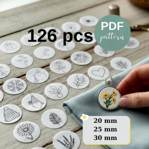May include: An image showing 126 embroidery pattern pieces with floral and seasonal designs. A finished pendant with yellow flowers is visible. Size options are 20 mm, 25 mm, and 30 mm.