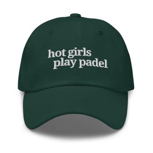 May include: A dark green baseball cap with the embroidered text "hot girls play padel" in white. The cap has a curved brim and a button on top. This hat is a stylish accessory for sports enthusiasts.