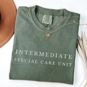 May include: A green t-shirt with the text "INTERMEDIATE SPECIAL CARE UNIT" printed in white on the front.