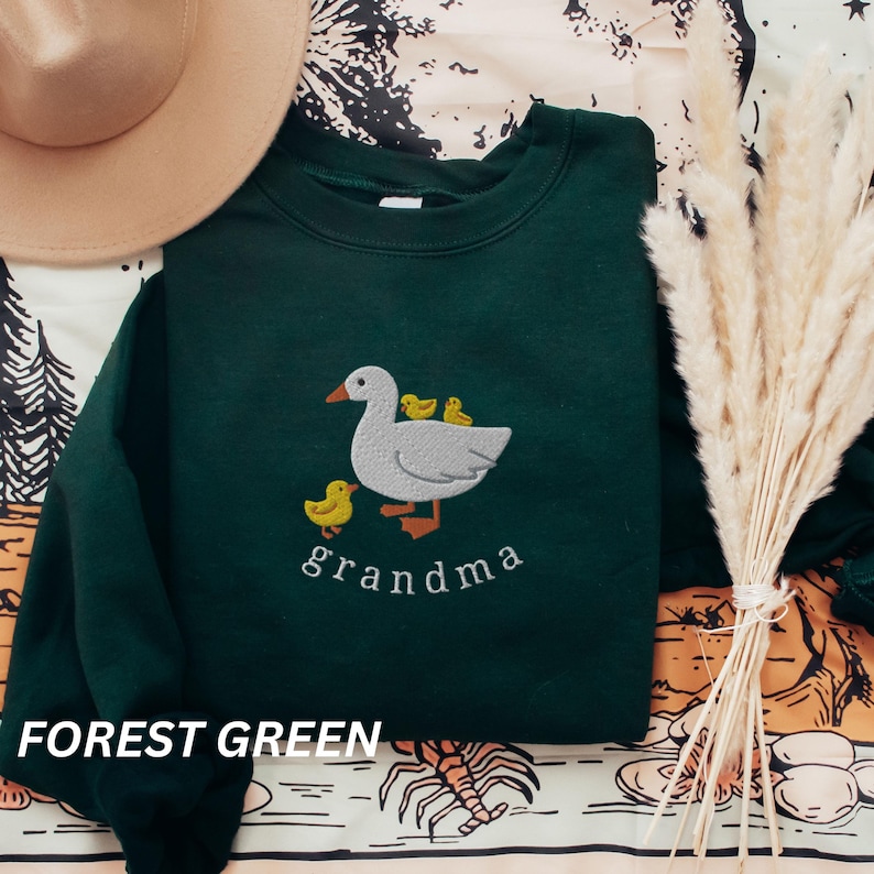 May include: Forest green sweatshirt with an embroidered design of a goose with three goslings and the word "grandma".