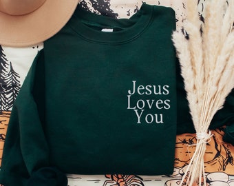 May include: A dark green sweatshirt with the text "Jesus Loves You" embroidered in white on the front.