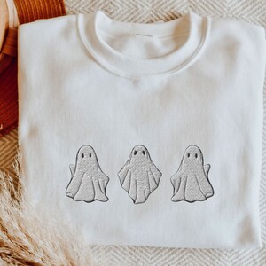May include: White sweatshirt with three embroidered gray ghosts.