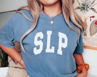 May include: A blue t-shirt with the letters "SLP" printed in white on the front. The shirt is made of a soft, comfortable material and has a relaxed fit.