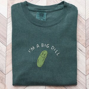 Cute Embroidered Pickle Shirt in Blue Spruce which is a dark green color, Comfort Colors brand, says "I'm a big dill" in capital letters