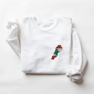 May include: White sweatshirt with an embroidered outline of Lebanon with the Lebanese flag colors and cedar tree inside.