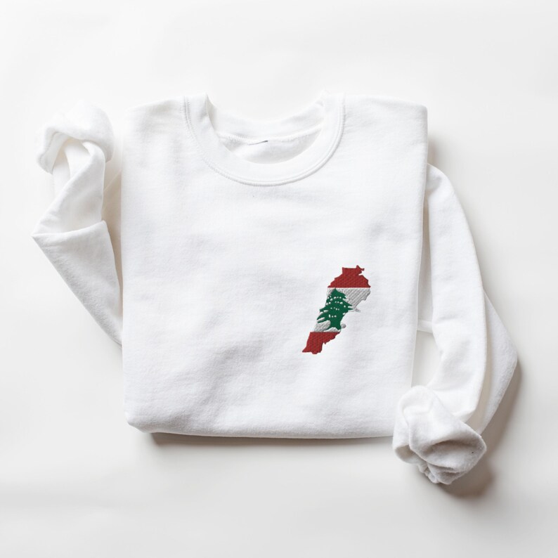 May include: White sweatshirt with an embroidered outline of Lebanon with the Lebanese flag colors and cedar tree inside.