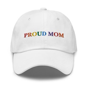 May include: White baseball cap with the text "PROUD MOM" embroidered in rainbow colors.