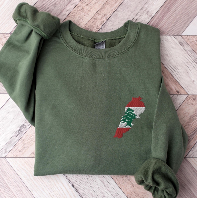 May include: A green sweatshirt with an embroidered outline of Lebanon with the Lebanese flag colors inside.