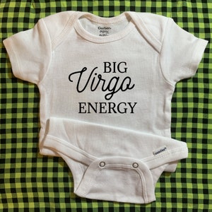 May include: White baby onesie with black text that reads "BIG Virgo ENERGY".