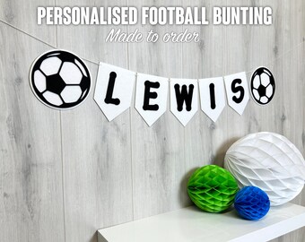 May include: White felt bunting with black felt letters spelling "LEWIS" and black and white felt soccer balls. The bunting is strung on a white string. The bunting is made to order.