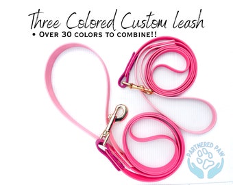 May include: Three-colored custom leash in pink, light pink, and dark pink. The leash is made of durable, flexible material and features a gold metal clasp. The text "Three Colored Custom Leash" and "Over 30 colors to combine!!" is visible in the image. The image also includes a logo for "Partnered Paw" with a paw print and two hands.