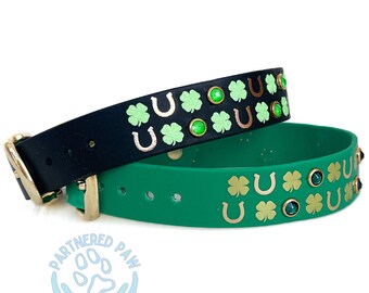 May include: Two dog collars, one black and one green, with gold horseshoe and four-leaf clover designs. The green collar has green and gold rhinestones.