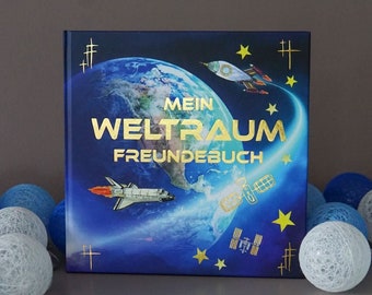 May include: A blue book with a gold foil design featuring a globe, stars, and spaceships. The title of the book is "Mein Weltraum Freundebuch".