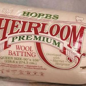 May include: A package of Hobbs Heirloom Premium Wool Batting, Queen size 90" x 108" (228.6 x 274.3 cm). The packaging is clear plastic with red, green, and white text. The product is developed with Harriet Hargrave.