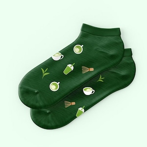 May include: A pair of green ankle socks with a pattern of matcha tea cups, boba tea, and matcha whisks.