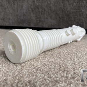 May include: White 3D printed prop resembling a futuristic weapon with a textured barrel and two buttons on the side.