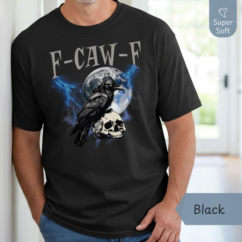 Black short-sleeve graphic T-shirt for men featuring a bold “F-CAW-F” design with a raven perched on a skull, set against a full moon with blue lightning. Modeled indoors in a casual setting, this super soft cotton tee is perfect for fans of edgy, gothic, or Halloween-inspired apparel. Ideal for gifting or everyday streetwear during the fall season. Available in various sizes through Phrase Art Studio’s Etsy shop.